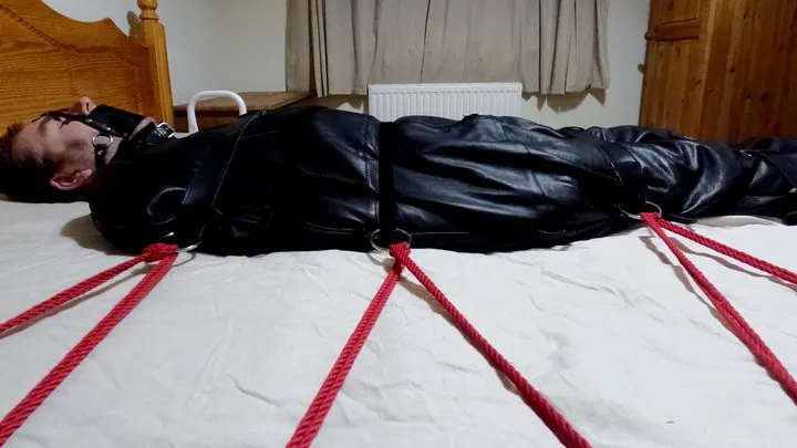 Miss M examines her helpless victim in a leather bound sleepsack