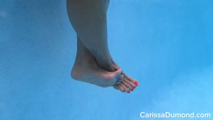 Bare feet and legs underwater and on display in the resort pool