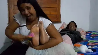 Lalita tickles Rebeca's feet