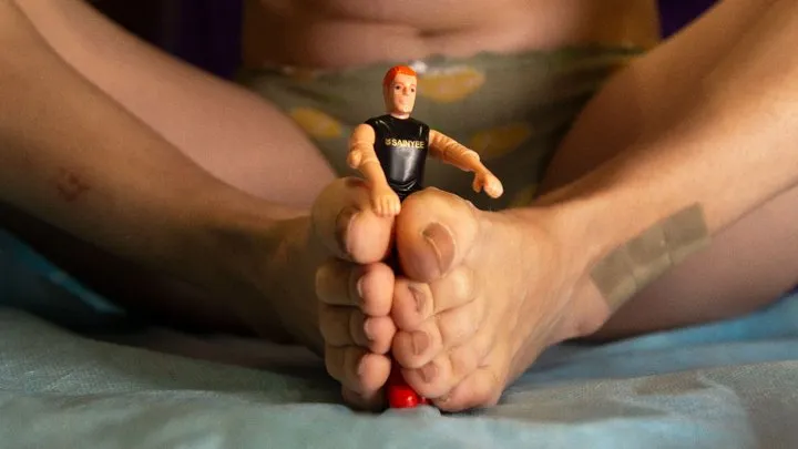 Little guy between giantess feet