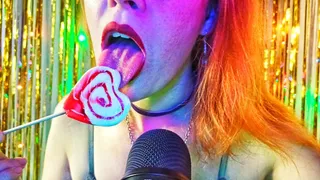 A redhead girl sensually licks a heart-shaped candy