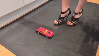 Giantess Raven Lee crushes a Plymouth Barracuda toy car in sexy heels with painted toenails right view