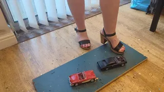 Giantess Lou crushes two old model cars Chevy corvette & Chevy Malibu in big heels high left view