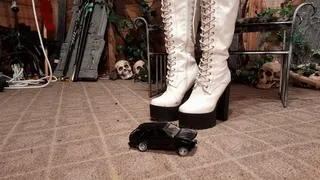 Fallen Raven wearing knee high white boots crushes toy car SUV ground view