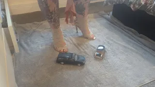 Jayne Vs Volvo V70 & classic mini toy car crush in snakeskin heels with painted toe nails high view