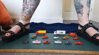 Giantess Jayne crushes 14 wiking tiny toy cars and trucks in chunky black flat sandals closeup ground view