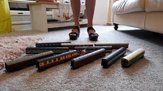 GIANTESS Charn crushes 10 toy model train coaches in black wedges closeup ground view