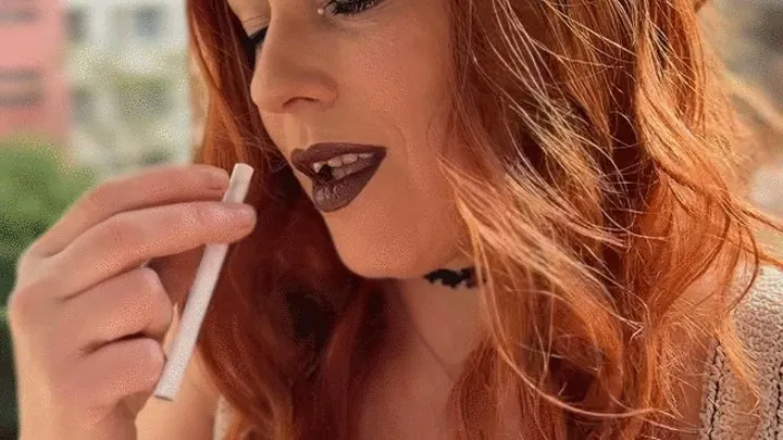 Pretty redhead JoJo smoking outside on the balcony