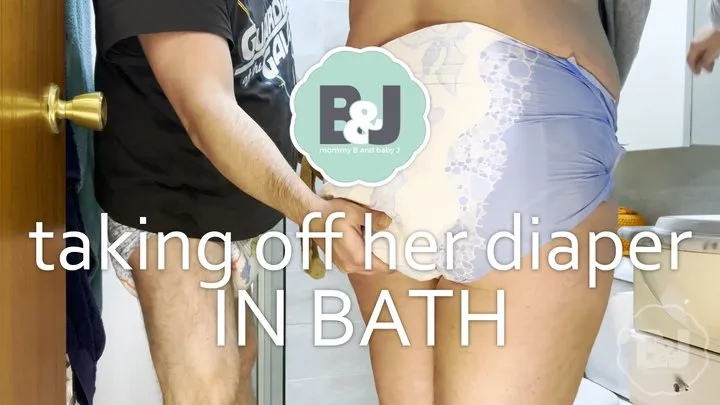 Taking off her diaper in bath