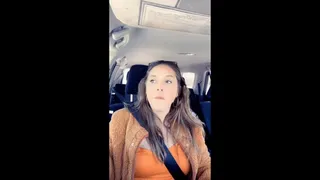 Smoking vaping in orange coat in car