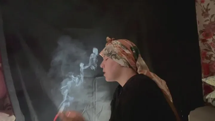 YULIANA LIGHTS HER CIGARETTE WHILE WEARING A HEAD SCARF