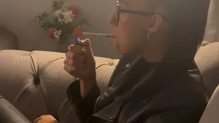 Smoking in full leather outfit on sofa