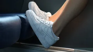 Rude girl places her dirty sneakers shoes on the train seat