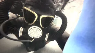 Female Wetsuit Dives in Gasmask Underwater