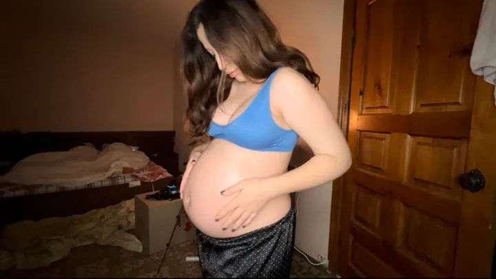 a pregnant woman anoints her tummy with oil from stretch marks