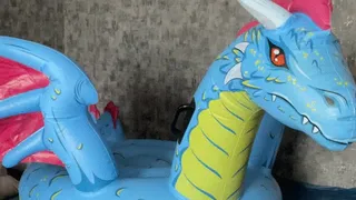 Val riding on inflatable dragon