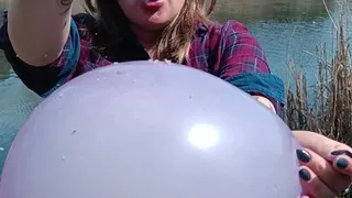 smoking girl blow and poping balloons in latex glove on nature