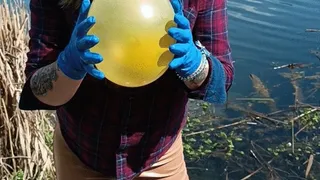 girl in gloves blowtopop balloon on nature