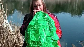 girl blowing big beachball on nature