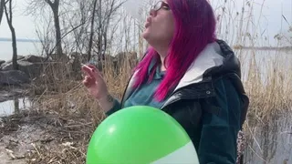 Smoking loner on nature blowing balloon with cigarette