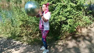 blowiing big hrom balloon on nature and sittopop
