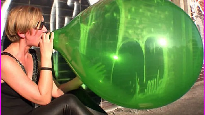 Lo blows up a large green Balloon until it Pops