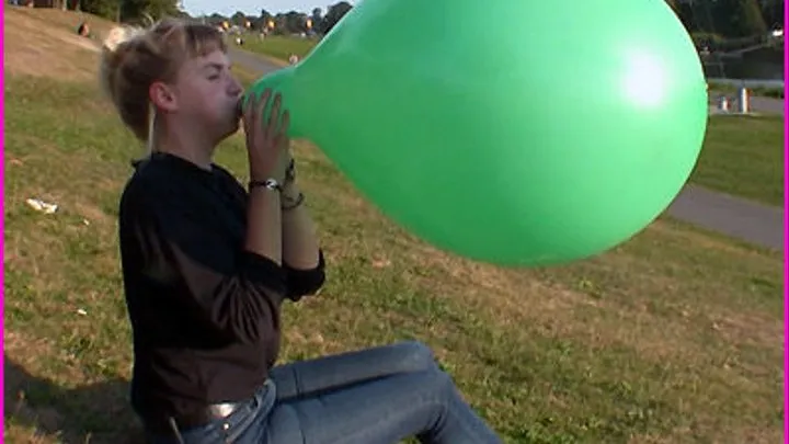 Alina blows up a green Balloon