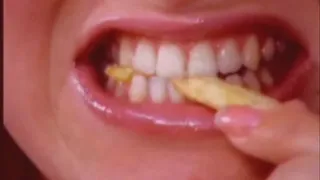 Extreme close up of teeth crushing fries