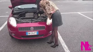 Inspecting my car's open hood in black pumps and seamed pantyhose