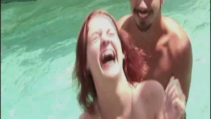 Topless redhead cutie tickled in the pool