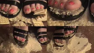 Kelly is Crushing crackers and trying to shake them out of her black strappy sandels & toes!!!