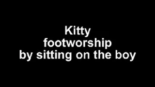 Kitty footworship by sitting on a boy