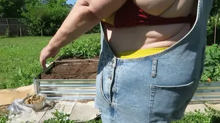 Farmer Nurse Vicki plants her pototes in her garden in cute overalls, a mask, boots and under why a bikini