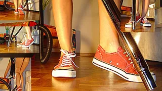 Vacuuming the floor in red sneakers