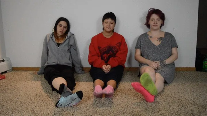 Alice, Dylan, and Rhea pose their socked and bare feet