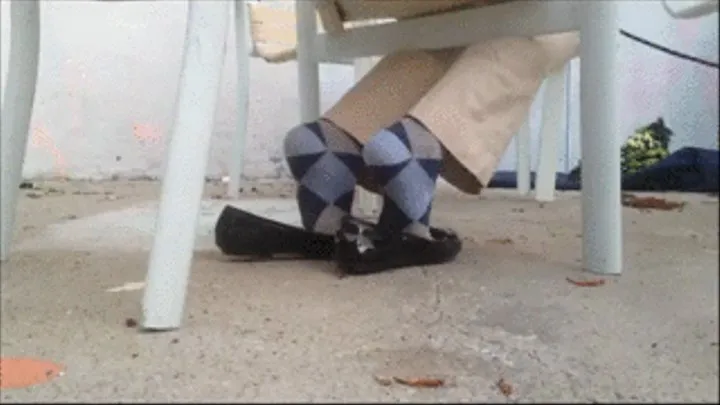 Argyle socks & penny loafers crossed ankle under chair