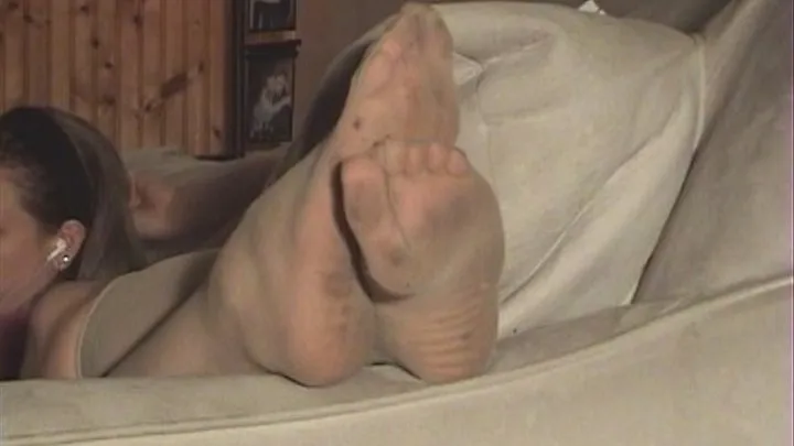 DIRTY NYLON SOLES RELAXING ON ARM OF COUCH