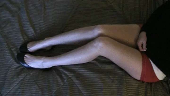 Toe dangling black flats barefoot on the bed