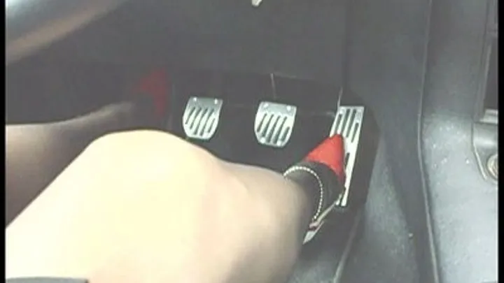 she is driving in her white and red stiletto heels