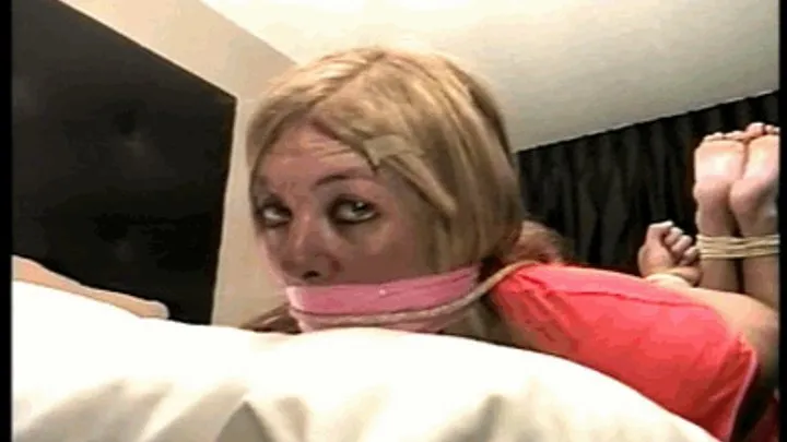 42 YEAR OLD MODEL IS WRAP BONDAGE TAPE GAGGED, HOG-TIED, BAREFOOT AND TOE-TIED ON THE BED