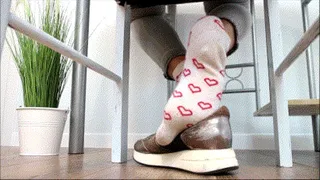 Dipping white socks with red heart in black shoes