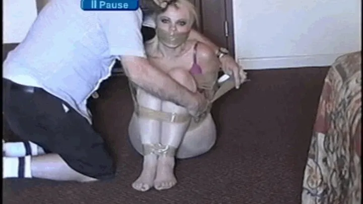 SEXY AND CUTE BLONDE MODEL IS PUT IN TRANS, MOUTH STUFFED, WRAPPED PACKAGING TAPE GAGGED, TAPE UP WITH PACKAGING TAPE, BALL-TIED, TOE-TIED,HANDGAGGED, GAG TALKING AND WEARING ONLY A BRA AND PANTYHOSE