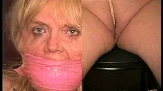 50 Yr OLD REAL ESTATE AGENT IS NUDE, TIT TIED, CROTCH ROPED, WRAP BONDAGE TAPE GAGGED, CLEAR TAPE GAGGED AND HANDGAGGED WHILE TIED TO A CHAIR