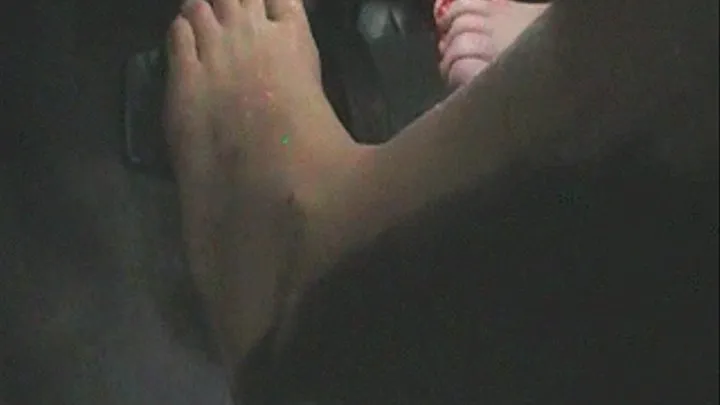 Two girls rub feet then take turns driving pedal footage