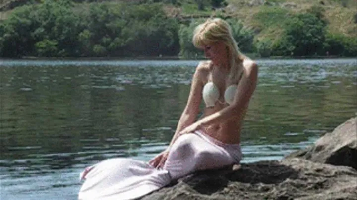 Mermaid Alina posing and topless at a river
