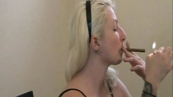 Olivia smokes a cigar, and coughs hard, hocks, and spits into an ashtray