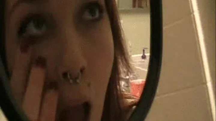 Eris examines the inside of her mouth in a hand mirror