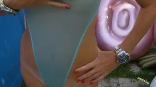 In a outdoor pool in see thru swimsuit and gymnastic shoes