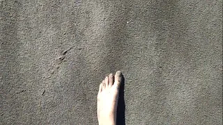 Feet sinking deep into beach sand