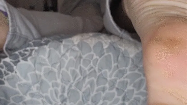 Dirty soles hanging off bed